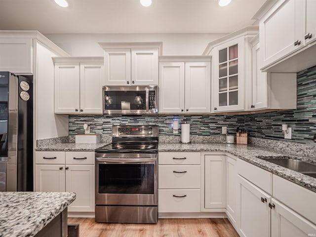 8675 Pebble Creek Dr, Newburgh, IN 47630 - kitchen with appliances with stainless steel finishes, recessed lighting, glass insert cabinets, decorative backsplash, and light wood-style flooring
