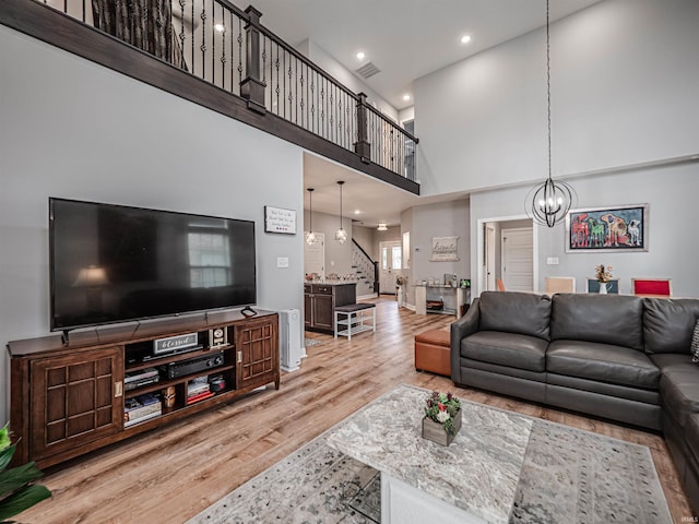 8675 Pebble Creek Dr, Newburgh, IN 47630 - living area featuring stairway, light wood-type flooring, a chandelier, a high ceiling, and recessed lighting
