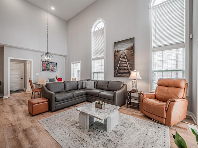 8675 Pebble Creek Dr, Newburgh, IN 47630 - living area featuring a towering ceiling, a chandelier, and light wood-style flooring