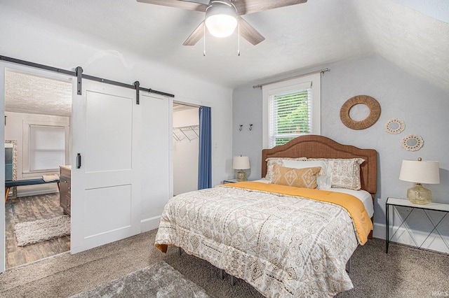 914 Golden Ave, South Bend, IN 46616 - carpeted bedroom featuring a barn door, a textured ceiling, a closet, a ceiling fan, and vaulted ceiling