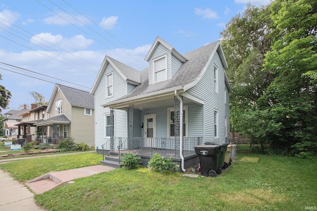 914 Golden Ave, South Bend, IN 46616 - view of front facade with covered porch, a shingled roof, and a front lawn