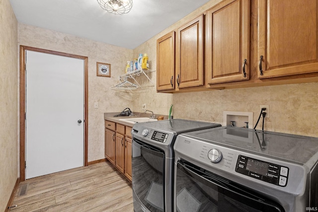 32750 Deer Watch Ct, New Carlisle, IN 46552 - washroom with washing machine and clothes dryer, cabinet space, and light wood-style flooring