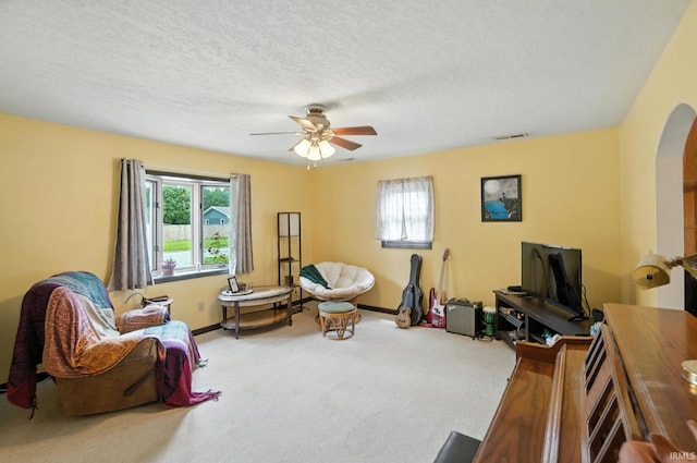 2707 Stanford Ave, Fort Wayne, IN 46808 - living area with arched walkways, plenty of natural light, carpet flooring, a ceiling fan, and a textured ceiling