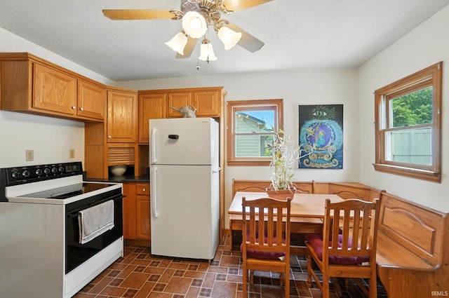2707 Stanford Ave, Fort Wayne, IN 46808 - kitchen with white appliances, brown cabinetry, ceiling fan, and dark countertops