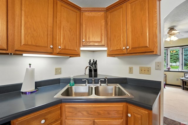 2707 Stanford Ave, Fort Wayne, IN 46808 - kitchen with dark countertops, a ceiling fan, and brown cabinetry