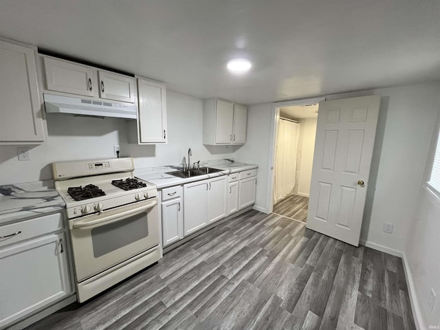 410 N Jay St, Kokomo, IN 46947 - kitchen featuring white gas stove, under cabinet range hood, dark wood-style flooring, light countertops, and white cabinets