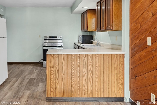 19629 Gilmer St, South Bend, IN 46614 - kitchen featuring appliances with stainless steel finishes, wood finished floors, light countertops, and a peninsula