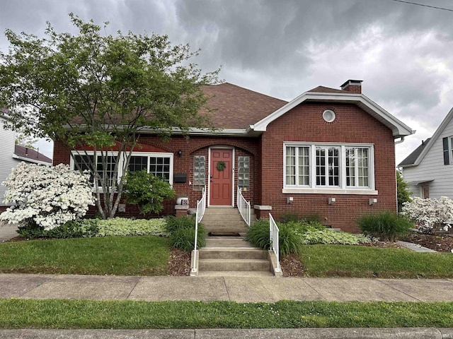 325 W 5th St, Jasper, IN 47546 - bungalow-style home featuring brick siding, a chimney, crawl space, and a front lawn