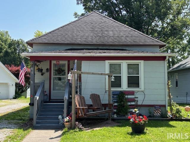 307 N Madison Ave, Fowler, IN 47944 - view of front of property featuring roof with shingles, a porch, and a front lawn
