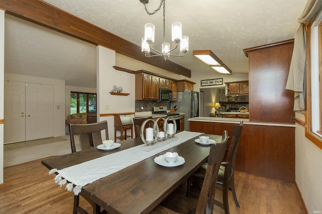 12069 N Timberline Trce, Granger, IN 46530 - dining room featuring a chandelier, light wood-type flooring, and a textured ceiling