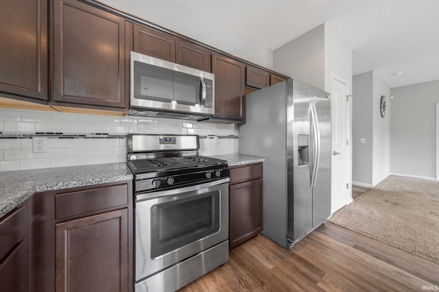 13233 Mera Cv, Fort Wayne, IN 46814 - kitchen featuring stainless steel appliances, tasteful backsplash, dark brown cabinetry, dark wood finished floors, and stone countertops