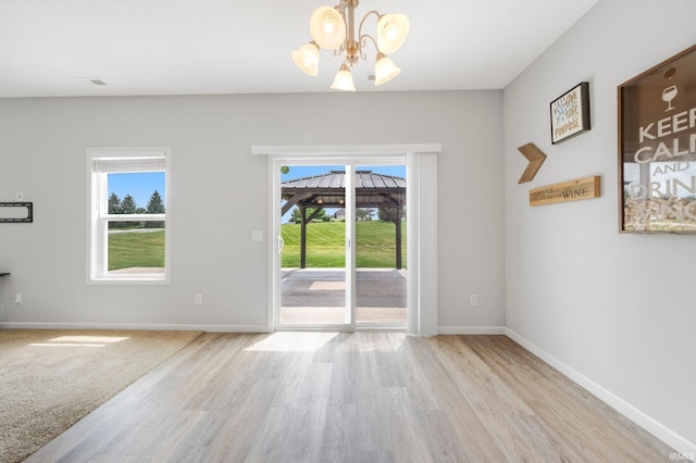 13233 Mera Cv, Fort Wayne, IN 46814 - spare room featuring a chandelier, healthy amount of natural light, and wood finished floors