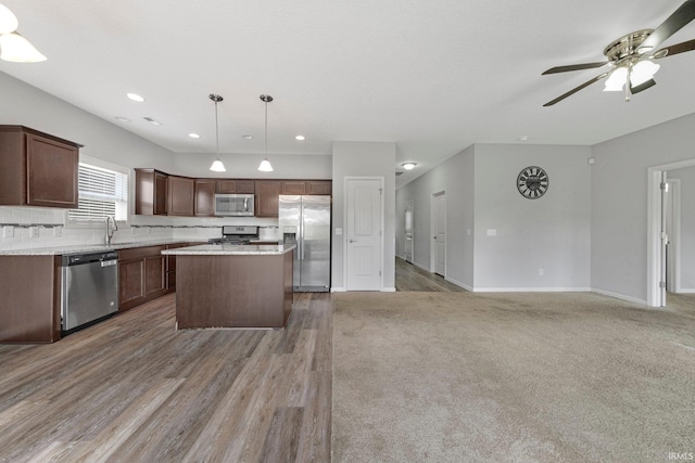 13233 Mera Cv, Fort Wayne, IN 46814 - kitchen with appliances with stainless steel finishes, open floor plan, a center island, hanging light fixtures, and a ceiling fan