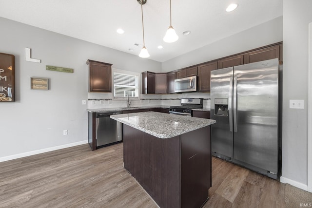 13233 Mera Cv, Fort Wayne, IN 46814 - kitchen featuring stainless steel appliances, dark brown cabinetry, a kitchen island, pendant lighting, and wood finished floors