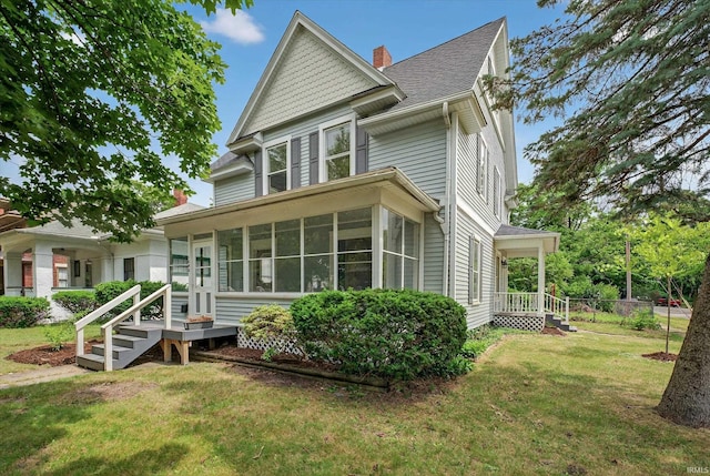 1060 Woodward Ave, South Bend, IN 46616 - rear view of property featuring a sunroom, a lawn, a chimney, and roof with shingles