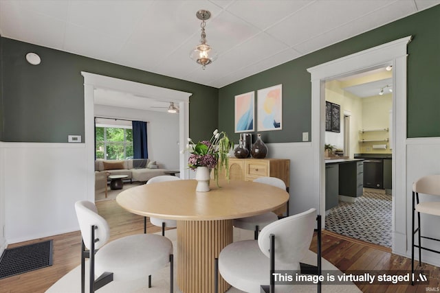 1060 Woodward Ave, South Bend, IN 46616 - dining room featuring wood-type flooring, ceiling fan, and a wainscoted wall