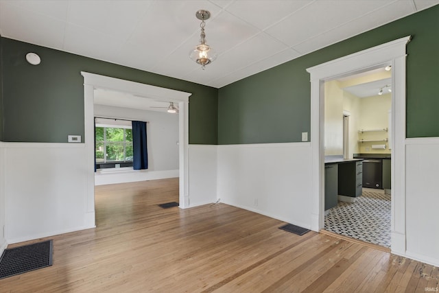 1060 Woodward Ave, South Bend, IN 46616 - spare room featuring a wainscoted wall, light wood-style flooring, a ceiling fan, and a smoke detector