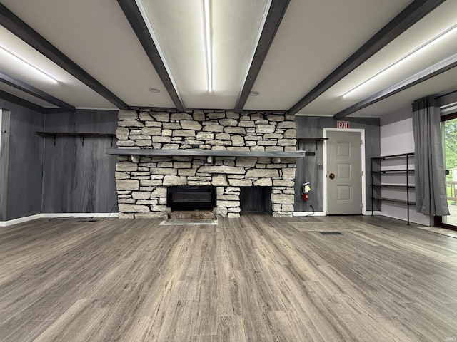 806 N Tippy Dr, Marion, IN 46952 - unfurnished living room with a stone fireplace, beam ceiling, and wood finished floors