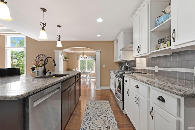 1176 W Whitetail Dr, Columbia City, IN 46725 - kitchen featuring appliances with stainless steel finishes, open shelves, arched walkways, ornate columns, and a chandelier