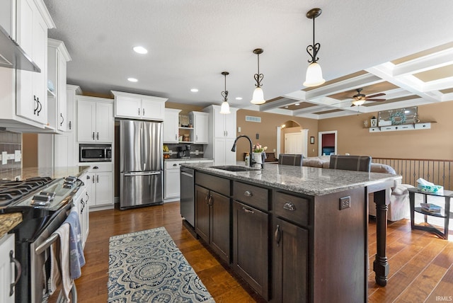 1176 W Whitetail Dr, Columbia City, IN 46725 - kitchen featuring appliances with stainless steel finishes, a ceiling fan, a breakfast bar area, dark brown cabinetry, and arched walkways