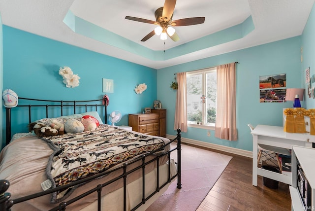1176 W Whitetail Dr, Columbia City, IN 46725 - bedroom with wood-type flooring, a tray ceiling, and ceiling fan
