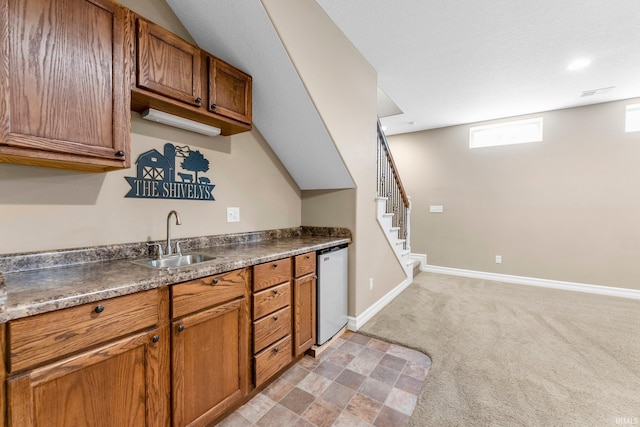 1176 W Whitetail Dr, Columbia City, IN 46725 - kitchen featuring dark countertops, brown cabinets, dishwashing machine, and light carpet