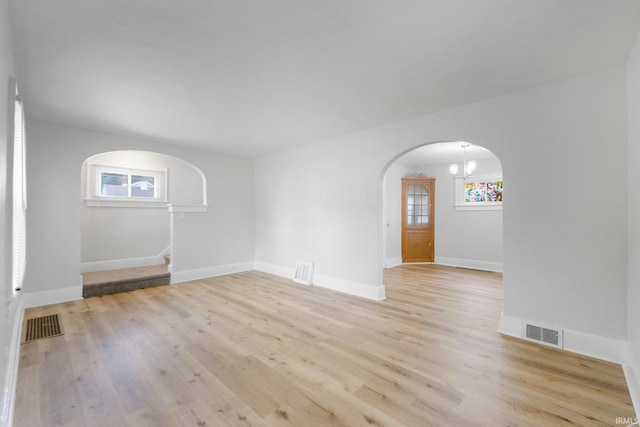 2318 Dodge Ave, Fort Wayne, IN 46805 - unfurnished room with arched walkways, light wood-type flooring, stairs, and a chandelier