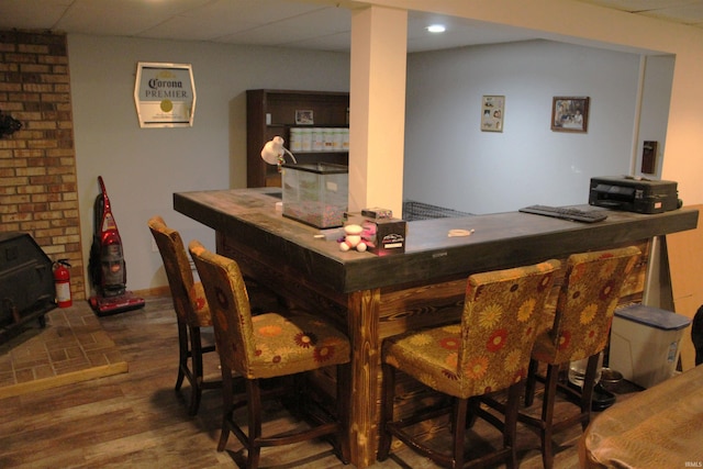 50859 Oak Tree Ln, Bristol, IN 46507 - bar with wood finished floors, a wood stove, and a drop ceiling