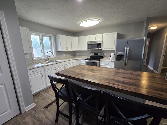 614 N Lancelot Dr, Marion, IN 46952 - kitchen with appliances with stainless steel finishes, butcher block counters, a textured ceiling, white cabinets, and dark wood-style flooring