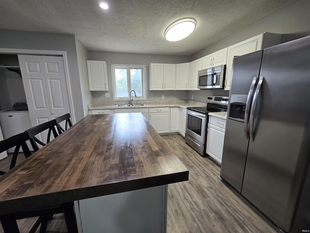 614 N Lancelot Dr, Marion, IN 46952 - kitchen featuring stainless steel appliances, wood counters, white cabinetry, a kitchen island, and a textured ceiling