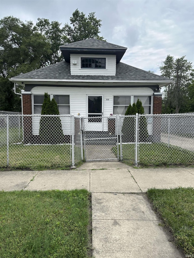 731 Johnson St, South Bend, IN 46628 - bungalow-style house with a gate, a fenced front yard, roof with shingles, and brick siding