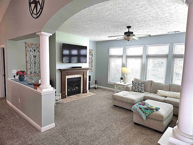3520 Lintel Dr, West Lafayette, IN 47906 - living area with ornate columns, a ceiling fan, carpet, a tiled fireplace, and arched walkways