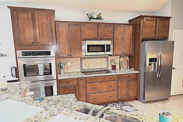 3520 Lintel Dr, West Lafayette, IN 47906 - kitchen featuring stainless steel appliances, decorative backsplash, light stone countertops, and light tile patterned floors