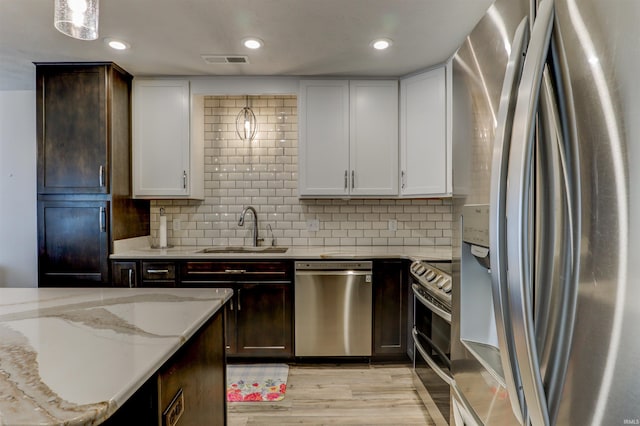 904-3 Reyling Dr, Jasper, IN 47546 - kitchen with stainless steel appliances, light wood-style floors, light stone counters, white cabinetry, and recessed lighting