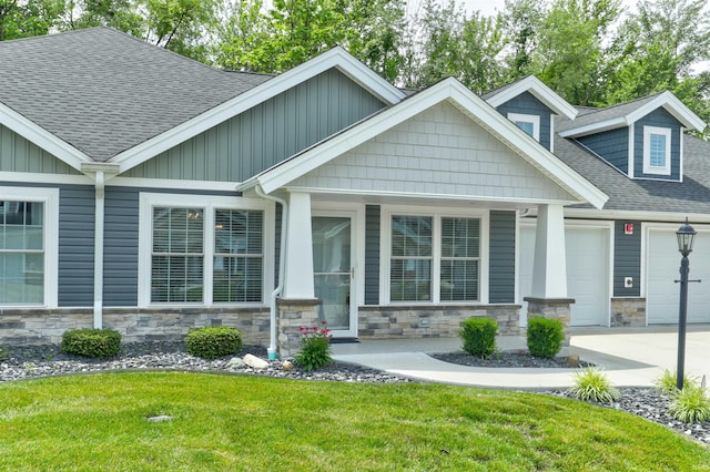 904-3 Reyling Dr, Jasper, IN 47546 - craftsman-style home featuring roof with shingles, stone siding, a front lawn, and an attached garage