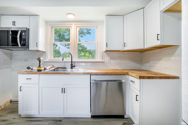 5729 Saint Joe Center Rd, Fort Wayne, IN 46835 - kitchen with stainless steel appliances, butcher block counters, white cabinetry, and backsplash