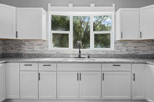 809 E 5th St, Fowler, IN 47944 - kitchen with white cabinetry, backsplash, and light stone countertops