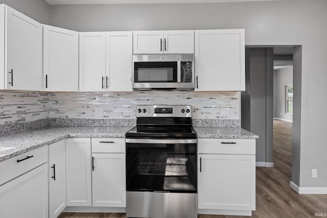 809 E 5th St, Fowler, IN 47944 - kitchen with stainless steel appliances, white cabinetry, wood finished floors, and light stone countertops