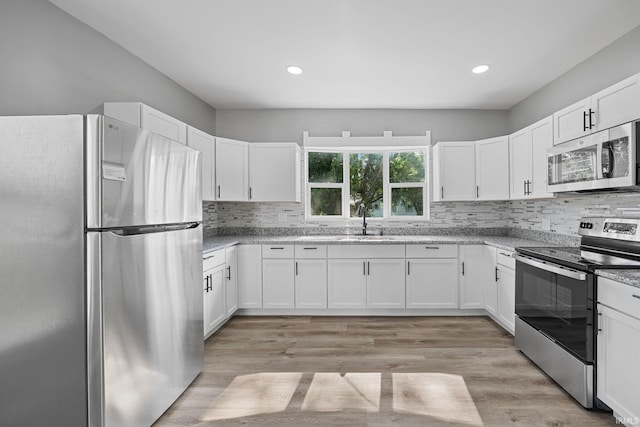 809 E 5th St, Fowler, IN 47944 - kitchen featuring stainless steel appliances, decorative backsplash, white cabinets, and recessed lighting