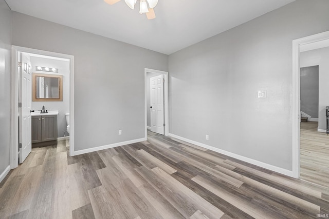 809 E 5th St, Fowler, IN 47944 - unfurnished bedroom featuring light wood-type flooring, ensuite bath, and ceiling fan