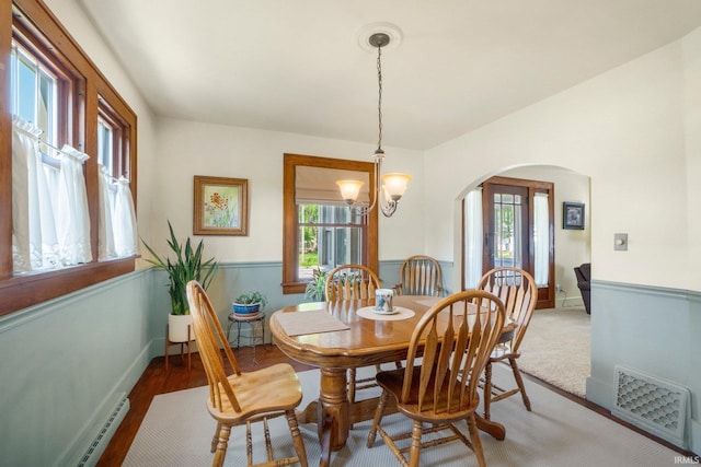 220 N Line St, Churubusco, IN 46723 - dining space with arched walkways, a baseboard heating unit, a chandelier, and light wood-style flooring