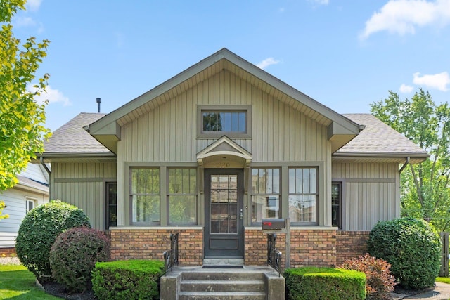 220 N Line St, Churubusco, IN 46723 - view of front of property with a shingled roof, brick siding, and board and batten siding