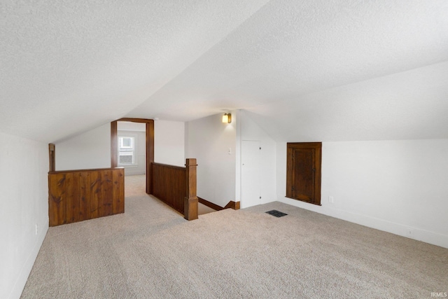 220 N Line St, Churubusco, IN 46723 - additional living space with vaulted ceiling, carpet floors, and a textured ceiling