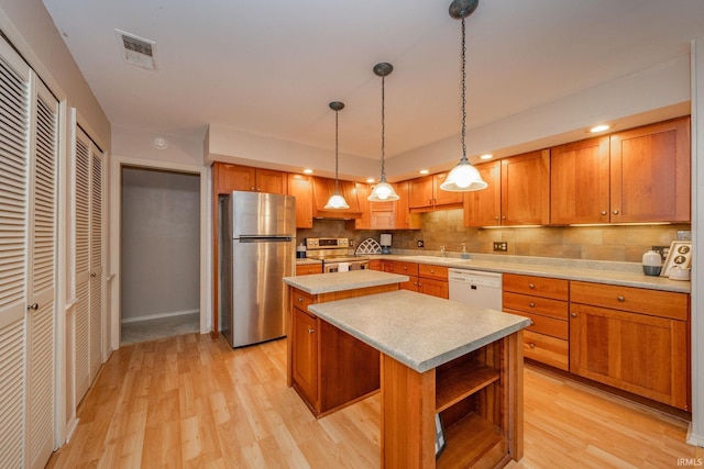 2613 Queensbury Rd, Muncie, IN 47304 - kitchen with appliances with stainless steel finishes, a kitchen island, light wood-style flooring, light countertops, and recessed lighting