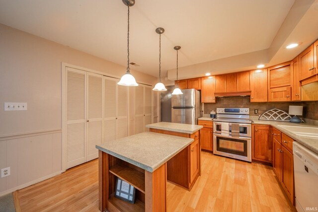 2613 Queensbury Rd, Muncie, IN 47304 - kitchen with appliances with stainless steel finishes, a kitchen island, light wood-type flooring, decorative backsplash, and open shelves
