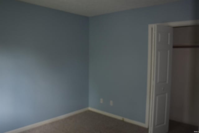 9335 S Lake Ridge Dr Unit Dm175, Bloomington, IN 47401 - unfurnished bedroom featuring dark carpet and baseboards