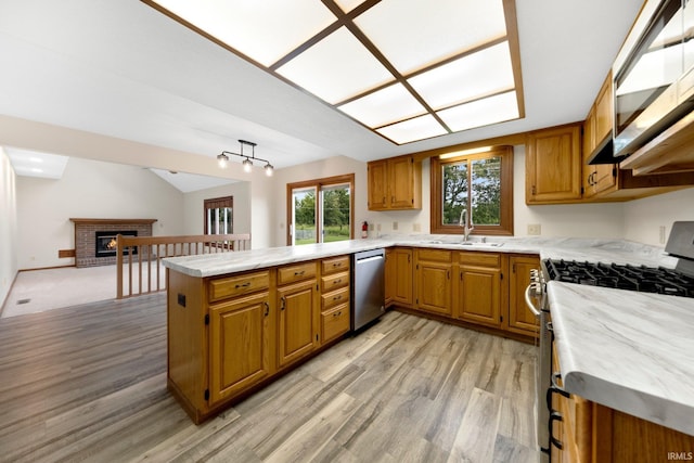 9106 Yellow Tree Ct, Fort Wayne, IN 46804 - kitchen with stainless steel appliances, a peninsula, light wood-type flooring, brown cabinets, and vaulted ceiling