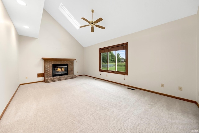 9106 Yellow Tree Ct, Fort Wayne, IN 46804 - unfurnished living room with ceiling fan, light carpet, a brick fireplace, high vaulted ceiling, and a skylight