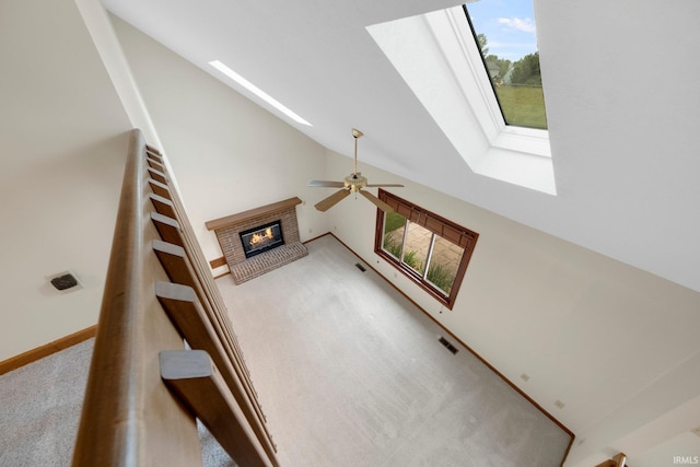 9106 Yellow Tree Ct, Fort Wayne, IN 46804 - stairway with a skylight, a fireplace, carpet, ceiling fan, and high vaulted ceiling