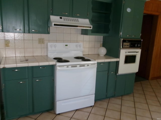 908 N Hawthorne St, Marion, IN 46952 - kitchen featuring white appliances, exhaust hood, green cabinetry, tile counters, and backsplash